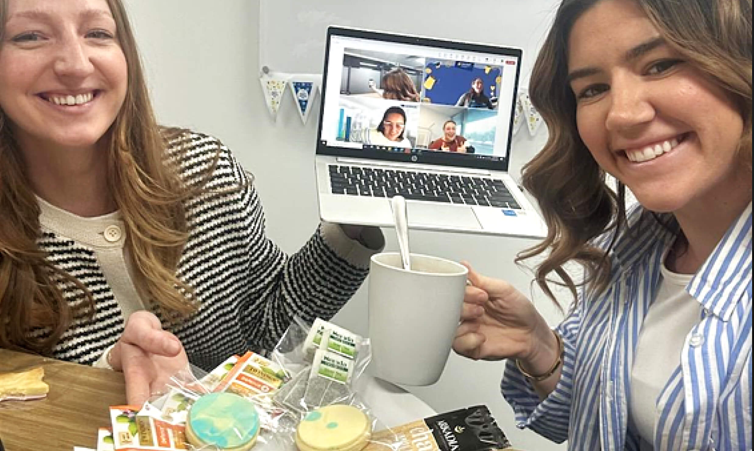 Two women with a laptop and some breakfast treats